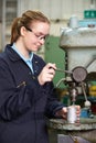 Female Apprentice Engineer Using Drill In Factory