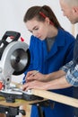 Female apprentice learning to use circular saw