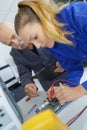 Female apprentice with teacher calibrating equipment