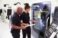 Female Apprentice Working With Engineer On CNC Machinery Royalty Free Stock Photo