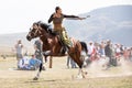 Female archer shooting an arrow on horseback.