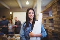 Female architect with blueprints while colleagues in background Royalty Free Stock Photo