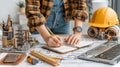 Female Architect Designing Blueprint at Desk with Tools and Models