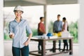 Female architect or engineer with blueprint at building construction site. Coworker meeting on blur background Royalty Free Stock Photo