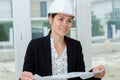 female architect holding plans inside property Royalty Free Stock Photo