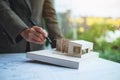 An architect holding and working on an architecture house model with shop drawing paper in the office Royalty Free Stock Photo