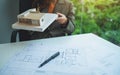 An architect holding and working on an architecture house model with shop drawing paper in the office Royalty Free Stock Photo