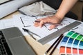Female architect or interior designer working on home floor plans at her studio desk with blueprints, color scheme palette Royalty Free Stock Photo