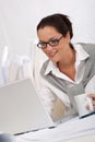 Female architect with laptop and coffee sitting