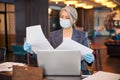 Female architect in medical mask studying documents at work Royalty Free Stock Photo