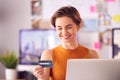 Female Architect In Office Working At Desk Making Online Purchase Using Credit Card On Laptop Royalty Free Stock Photo