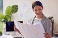 Female Architect Standing In Office Looking At Building Plans Royalty Free Stock Photo