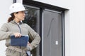 female architect stood outside property holding clipboard Royalty Free Stock Photo