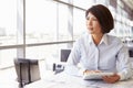 Female architect using tablet computer, looking away