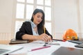 Female architect working on blueprint architects project in office Royalty Free Stock Photo