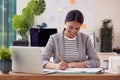 Female Architect Working In Office Sitting At Desk Studying Plans For New Building Royalty Free Stock Photo