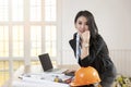 Female architect working standing at her desk with blueprint architects project in vintage office Royalty Free Stock Photo