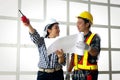 Two female architects ordered male workers to follow a blueprint, working collaboratively and achieving goals. Royalty Free Stock Photo