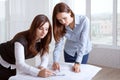 Female architects studying blueprints and make notes