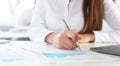 Female arm in suit hold silver pen and pad