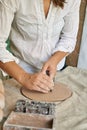 female artisan ceramist makes lettering impression on clay layer