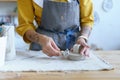 Female artisan work with raw clay in pottery studio. Young student girl prepare material for shaping Royalty Free Stock Photo