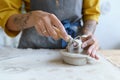 Female artisan work with raw clay in pottery studio. Young student girl prepare material for shaping Royalty Free Stock Photo