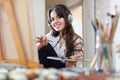 Female artist in headphones paints picture on canvas Royalty Free Stock Photo