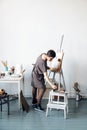 Female artist in her spacious white studio working with watercolor painting Royalty Free Stock Photo