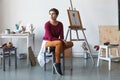 Female artist in her spacious white studio working with watercolor painting Royalty Free Stock Photo