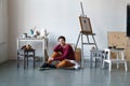 Female artist in her spacious white studio working with watercolor painting Royalty Free Stock Photo