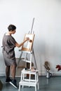 Female artist in her spacious white studio working with watercolor painting Royalty Free Stock Photo