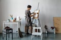 Female artist in her spacious white studio working with watercolor painting Royalty Free Stock Photo