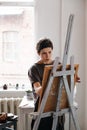 Female artist in her spacious white studio working with watercolor painting Royalty Free Stock Photo