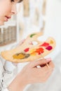 Female artist holding palette and mixing paint colors in studio Royalty Free Stock Photo