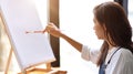 Female artist start painting on blank canvas on easel Royalty Free Stock Photo