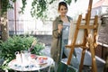 Female artist using paint brush while painting in backyard Royalty Free Stock Photo