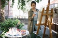 Female artist using paint brush while painting in backyard Royalty Free Stock Photo