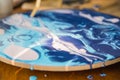 Female artist works on abstract fluid art painting with marble effect