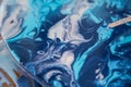 Female artist works on abstract fluid art painting with marble effect