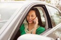 Female Asian driver using phone in a car