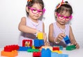 Female asian identical twins sitting on chair with white background. Wearing purple dress and accessories. Standing and playing on