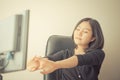 Female Asian office worker stretching out after long hour of work