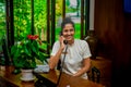 Female asian receptionist staff communicating using phone during duty hours at the tropical resort Royalty Free Stock Photo