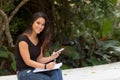 Female asian student sitting outside writing in notebook journal Royalty Free Stock Photo