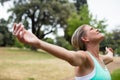 Female athlete with arms outstretched in park Royalty Free Stock Photo