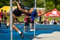 Female athlete captured in midair as she gracefully jumps over a hurdle