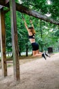 Woman doing monkey exercises on rings Royalty Free Stock Photo