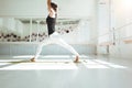 Female athlete doing stretching exercises listening in sunny sport gym in the morning Royalty Free Stock Photo