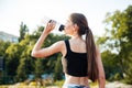Female athlete drinking from water bottle after workout at stadium Royalty Free Stock Photo